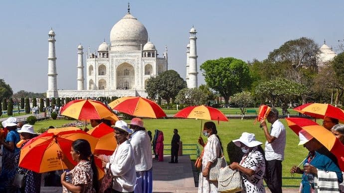Tourists shield themselves from the sun on a scorching day in Agra, Uttar Pradesh. (Photo: PTI)
